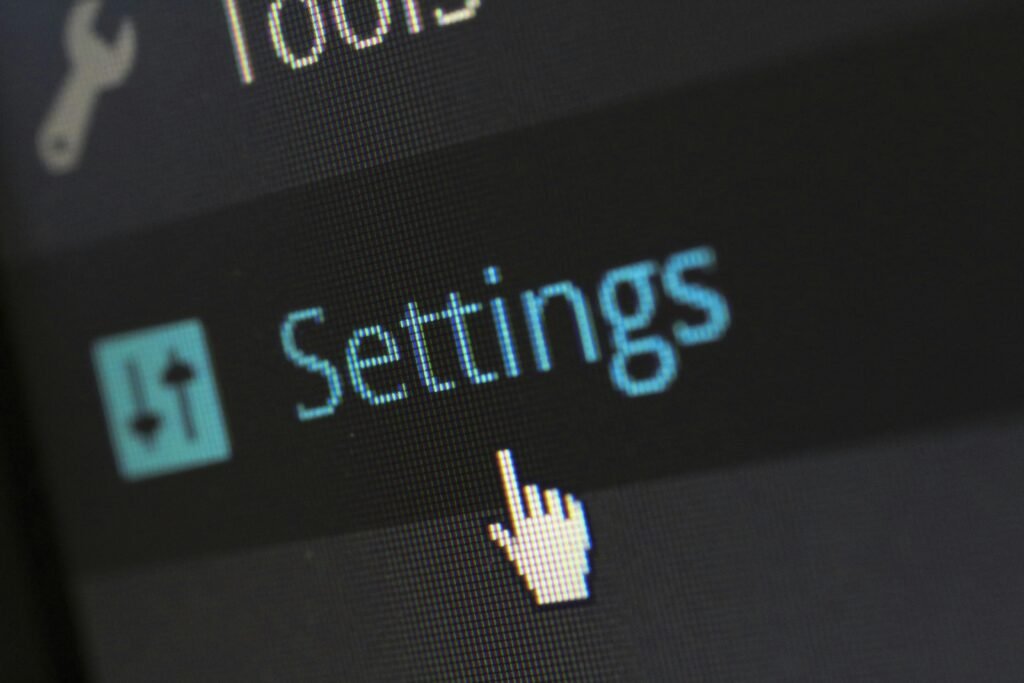 A close-up photo of a computer screen showing the settings button with a cursor hovering over it.
